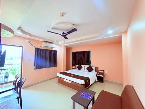 a bedroom with a bed and a couch and a table at ফোর স্কয়ার Four Square Lite Heaven Digha Near The Sea Beach in Digha
