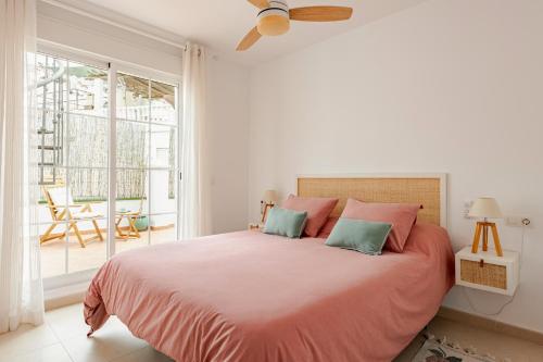 una camera da letto con un grande letto con cuscini rosa e verde di Wonder Atic, with private terraces, jacuzzi and stunning views a Cómpeta