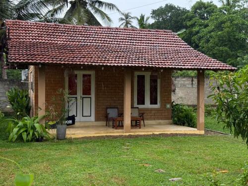 een klein bakstenen huis met een rood dak bij Eco Bricks in Ahangama