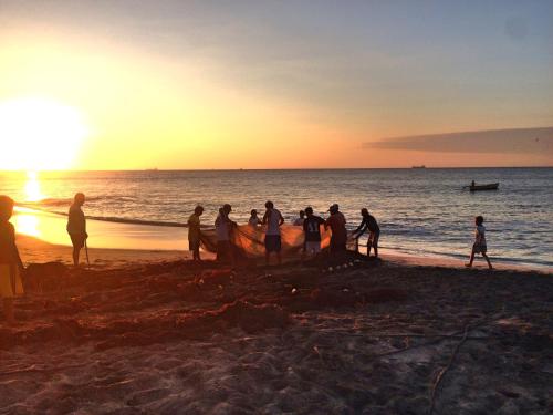 a group of people standing on the beach at sunset at Casa KoKopelli in Ballenita