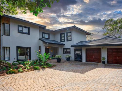 a large white house with a brick driveway at The First House Luxury Villa, Eden Rock Estate in Pennington