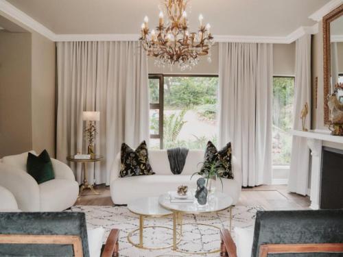 a living room with a white couch and a chandelier at The First House Luxury Villa, Eden Rock Estate in Pennington