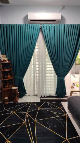 a living room with blue curtains and a couch at Mieda Rizqi Homestay in Kampong Melayu Changkat Larah
