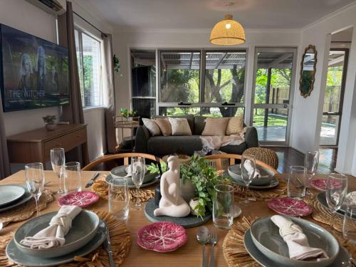 una sala de estar con una mesa con platos y vasos. en Chic Urban Escape in Norman Park, en Brisbane