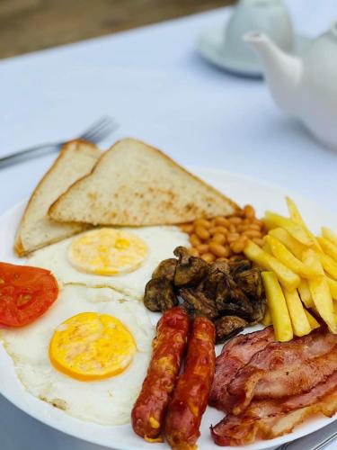 a plate of breakfast food with eggs sausage beans and toast at Blue Horizon Bed and Breakfast in Maseru