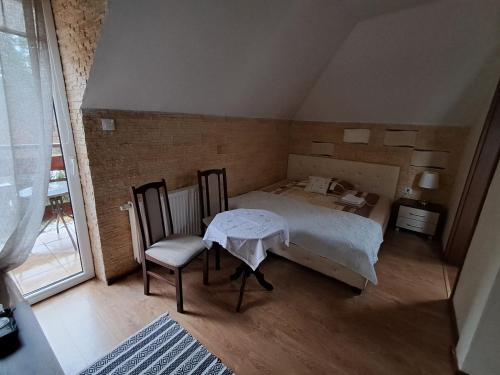 a room with a bed and a table and chairs at Noclegi Pod Dębem , Wiśniówka in Brzózki