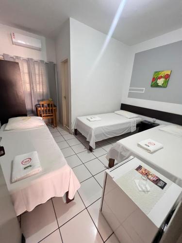 a hospital room with two beds and a table at Fabiel Palace Hotel in Cuiabá