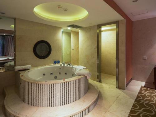 Un baño grande con una bañera grande en una habitación. en The Qube Shanghai Nanqiao, en Fengxian