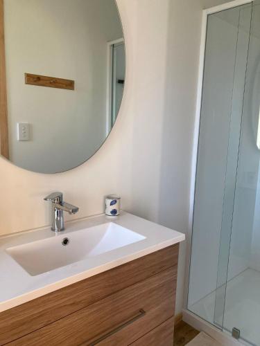 a bathroom with a sink and a mirror at Seascape on Maude in Oamaru
