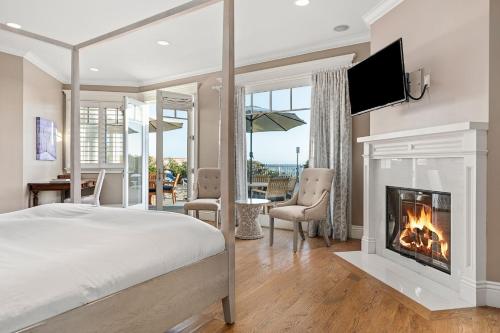 ein Schlafzimmer mit einem Kamin, einem Bett und einem TV in der Unterkunft Malibu Dunes by Fieldtrip Expansive Hamptons-Style Estate w Private Beach Backyard in Malibu