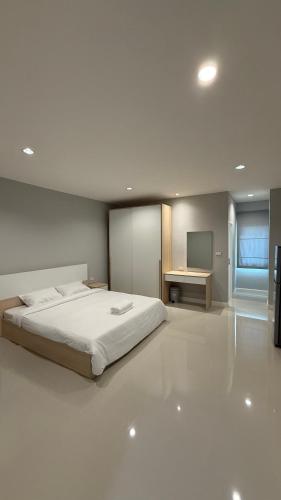 a bedroom with a bed and a desk and a television at Nene Apartment in Ban Bang Talat