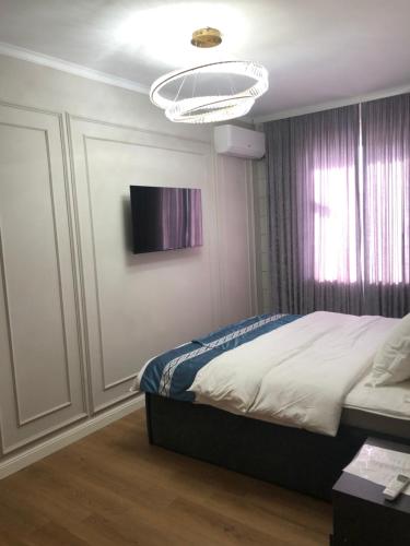 ein Schlafzimmer mit einem Bett und einem TV an der Wand in der Unterkunft Temirlan hotel in Schymkent