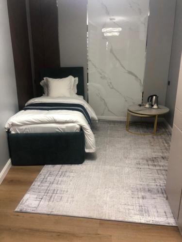 ein kleines Schlafzimmer mit einem Bett und einem Tisch in der Unterkunft Temirlan hotel in Schymkent