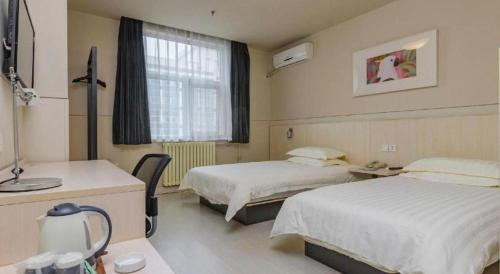 Ένα ή περισσότερα κρεβάτια σε δωμάτιο στο Jinjiang Inn Tai'an Taishan Railway Station