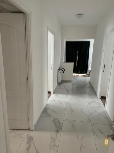 an empty hallway with white walls and marble floors at Casa Venus in Sînmartin