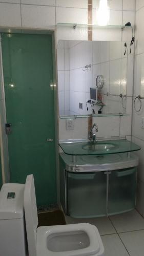 ein Badezimmer mit einem WC, einem Waschbecken und einem Spiegel in der Unterkunft Residencial Adam Lima in Belém