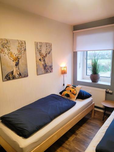 a bedroom with a bed with blue sheets and a window at Ferienwohnung Weidentriesch in Ayl