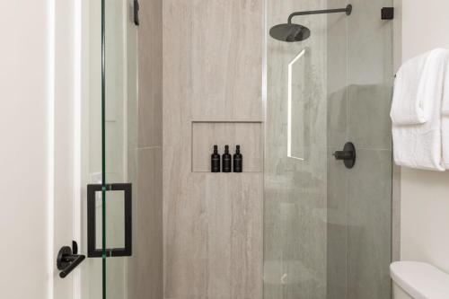 a shower with a glass door in a bathroom at Tide House - Unit A - Modern Seaside 1BD w Parking in El Segundo