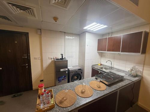 a kitchen with a counter top with plates on it at Suite one bedroom apartment Down town abudhabi in Abu Dhabi