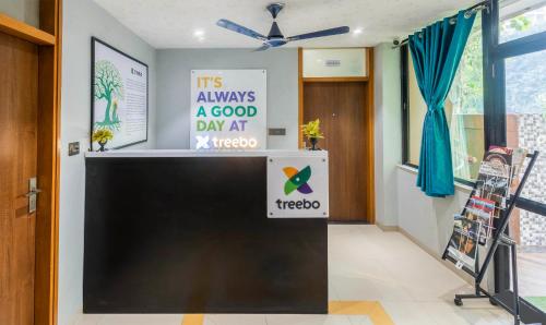 a large tv in a room with a sign on it at Treebo Executive Suites in Gandhinagar