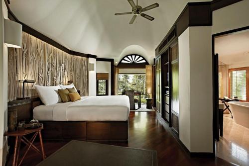 a bedroom with a large bed and a bathroom at Rayavadee - Deluxe Pavilion in Railay Beach