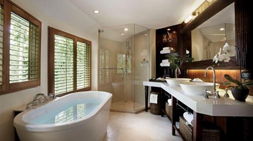 a bathroom with two sinks and a bath tub at Rayavadee - Deluxe Pavilion in Railay Beach