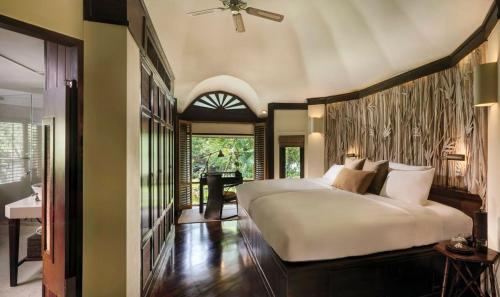 a bedroom with a large white bed and a desk at Rayavadee - Pool Pavilion in Railay Beach