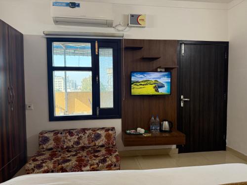 a bedroom with a bed and a window and a tv at HolidayVilla - 1st Japanese Pod, Rooms & Suites - Green Avenue Amritsar in Amritsar