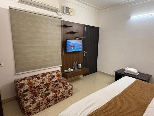 a hotel room with a bed and a couch at HolidayVilla - 1st Japanese Pod, Rooms & Suites - Green Avenue Amritsar in Amritsar