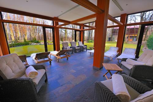 a conservatory with couches and chairs in a room with windows at Hotel Zochova Chata - Adult friendly in Modra