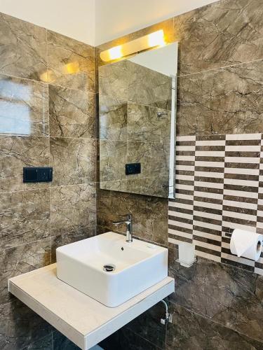 a bathroom with a white sink and a mirror at SKY Heaven in Weligama
