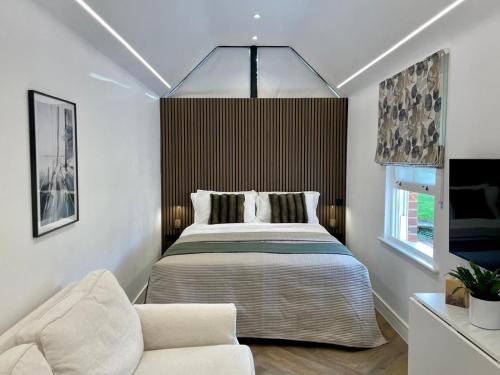 a bedroom with a bed and a chair in it at Boutique Cottage by Bishop's Stortford train station, easy to Stansted Airport & Parking in Bishops Stortford