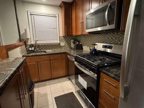 a kitchen with a stove and a microwave at Bright 2BR and1BA Home Near Old Town, Metro, Airport and Potomac Yard in Alexandria