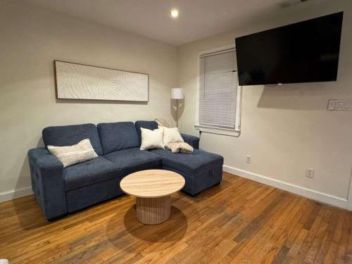 a living room with a blue couch and a table at Bright 2BR and1BA Home Near Old Town, Metro, Airport and Potomac Yard in Alexandria
