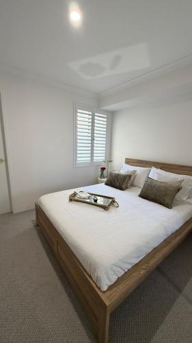 a bedroom with a large bed with a tray on it at Aweehomethevalley in Henley Brook