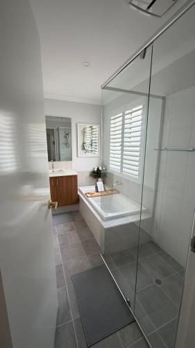 a bathroom with a tub and a glass shower at Aweehomethevalley in Henley Brook