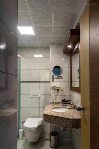 a bathroom with a toilet and a sink at Fame Beach Hotel in Kemer
