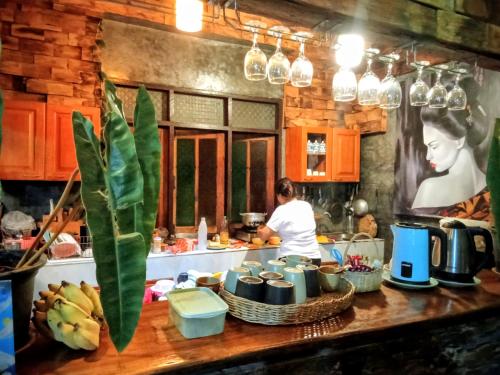 清迈Ouychai home stay resort的的厨房里的人在厨房里准备食物