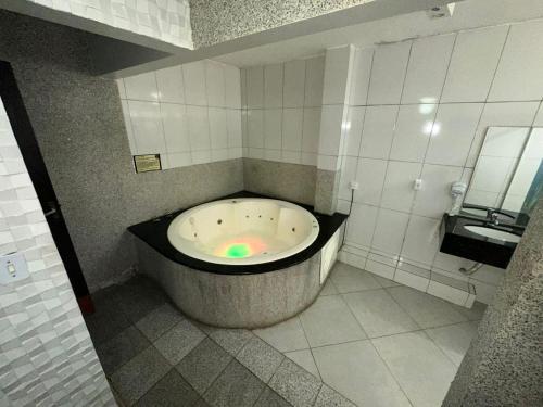 una grande vasca in un bagno con lavandino di Caribe Palace Hotel Taguatinga a Brasilia