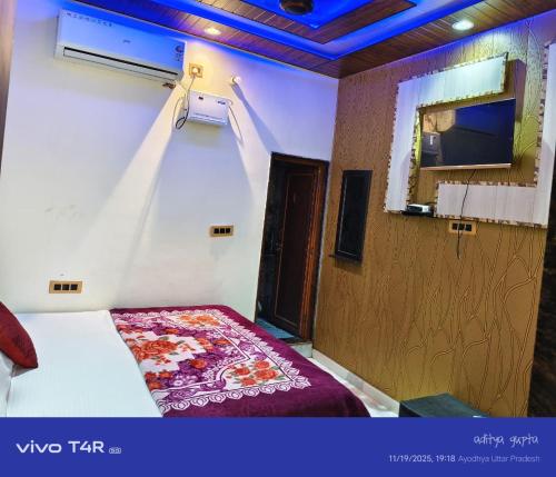 a hotel room with a bed and a window and a tv at Shree Ram Palace in Ayodhya