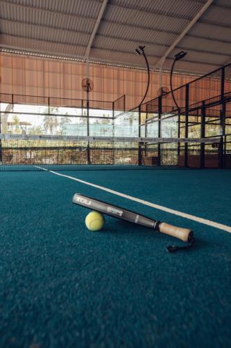 a bat and a ball on a tennis court at Sumberkima Hill 1 in Pemuteran