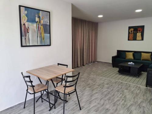 ein Wohnzimmer mit Tisch und Stühlen und einer Couch in der Unterkunft Appartement cosy a Djerba in Houmt Souk