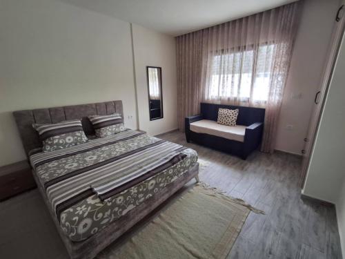 ein Schlafzimmer mit einem großen Bett und einem Stuhl in der Unterkunft Appartement cosy a Djerba in Houmt Souk