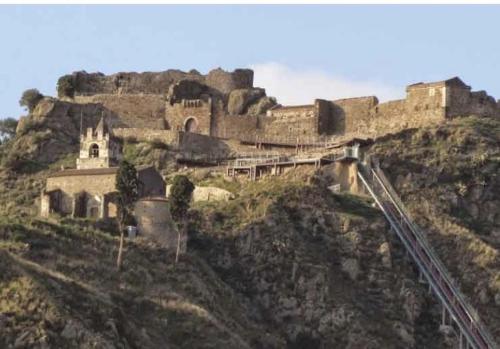 卡拉塔比亚诺Laura's cottage的一座城堡,位于山顶,设有火车轨道