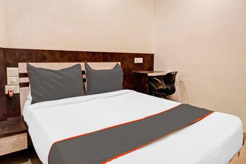 a bedroom with a large white bed and a desk at Collection O Royce Studios Near Pune Airport in Pune
