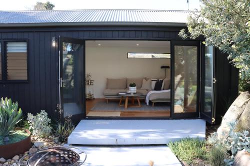a black shed with a living room in it at Driftwood Studio in Mount Martha