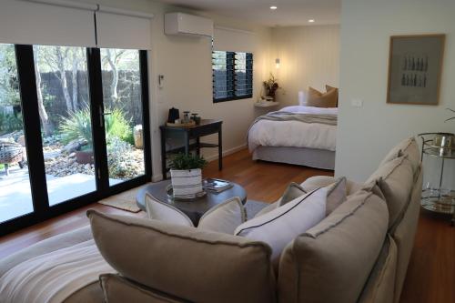 una sala de estar con un sofá y una cama en Driftwood Studio, en Mount Martha