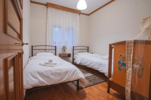 SarakinoíにあるRustic Houseのベッド2台と窓のある寝室