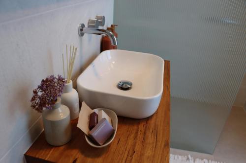 Un lavabo de baño sobre un mostrador de madera junto a una ducha. en Driftwood Studio, en Mount Martha