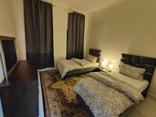a bedroom with two beds and a mirror at Delightful Private Rooms with Garden View in Sharjah